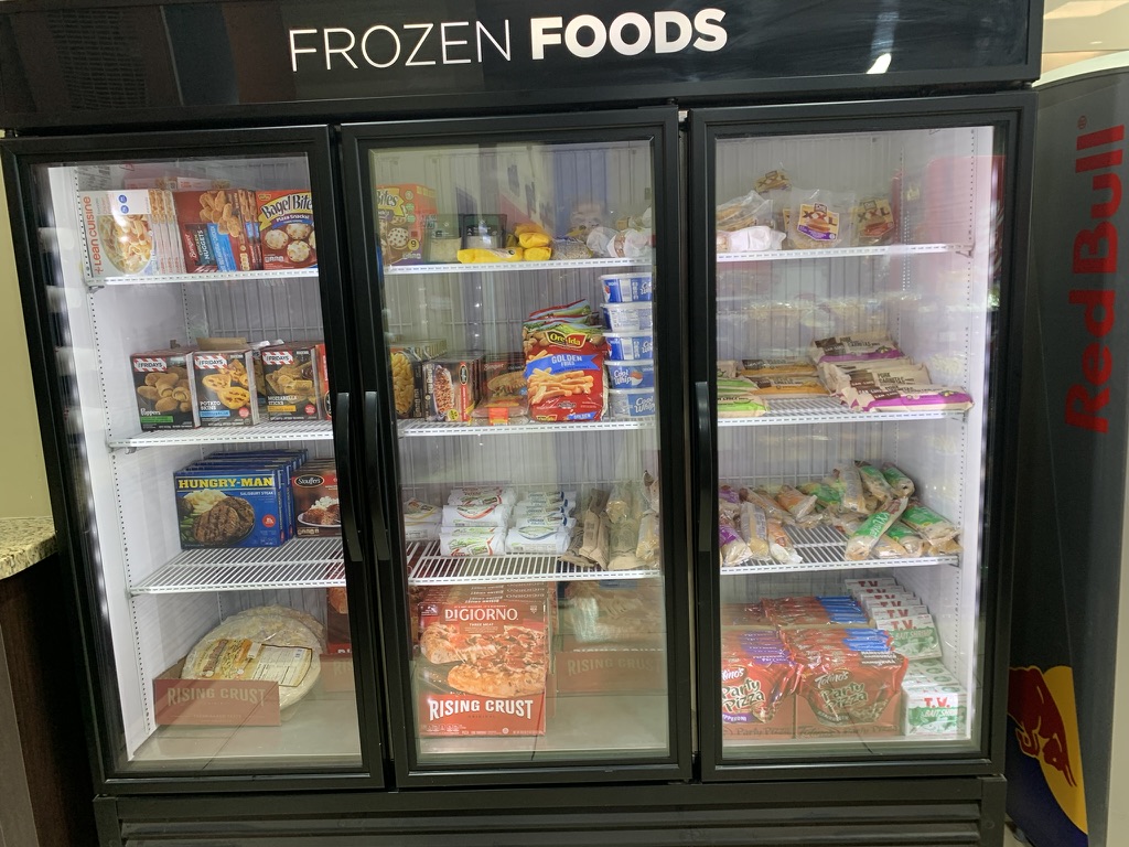 Three-door Frozen Foods freezer stocked with pizzas, snacks, and frozen meals